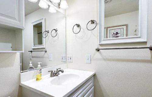 A white bathroom with a sink and mirror.