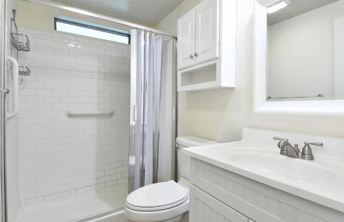 A white bathroom with a shower stall and sink.