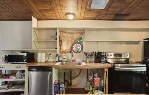 A kitchen with wooden ceilings and a sink.