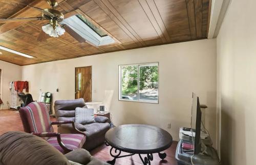 A living room with wood ceilings and a fan.