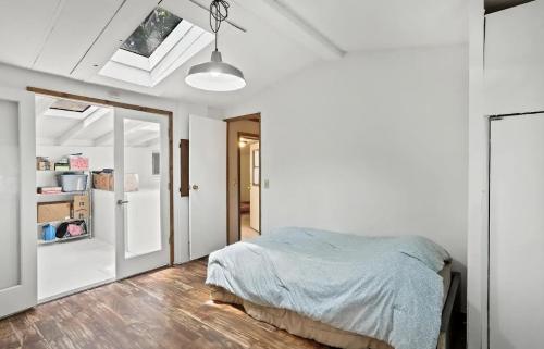 A bedroom with a skylight and wooden floors.