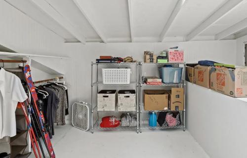 A white closet with skis and other items.