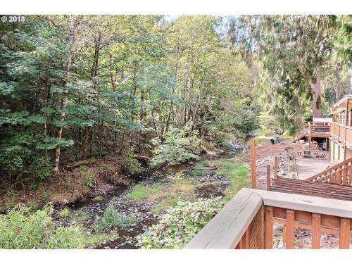 A deck overlooks a stream in the woods.
