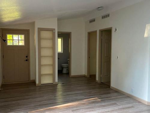 An empty room with hardwood floors and a door.