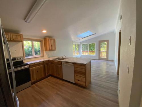 An empty kitchen with wood floors and a skylight.