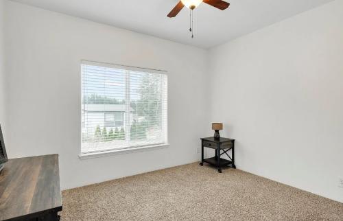An empty room with a ceiling fan and carpet.