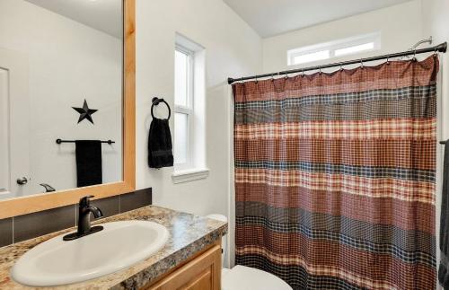 A bathroom with a plaid shower curtain.