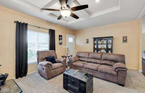 A living room with brown furniture and a ceiling fan.
