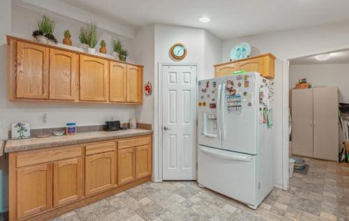 A kitchen with wood cabinets and a refrigerator.