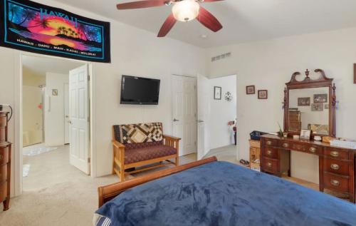 A bedroom with a ceiling fan and a poster on the wall.