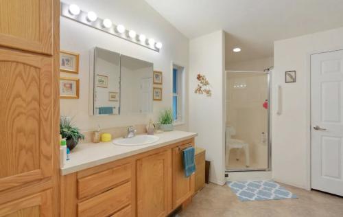 A bathroom with wooden cabinets and a shower stall.