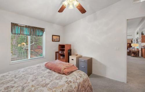 A bedroom with a ceiling fan and a bed.