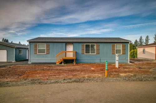 A blue mobile home sits on a gravel lot.