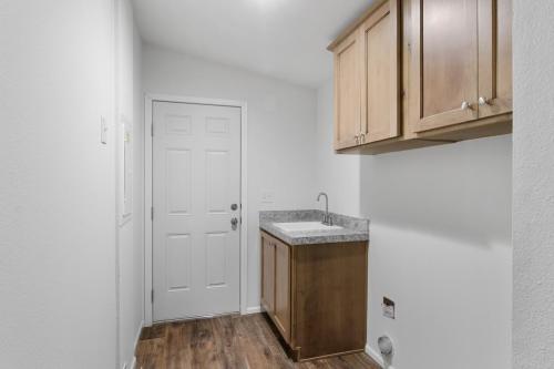 A small bathroom with wood cabinets and a sink.